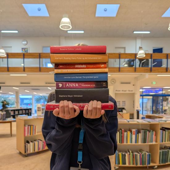 Praktikanten står og holder sine favorit bøger