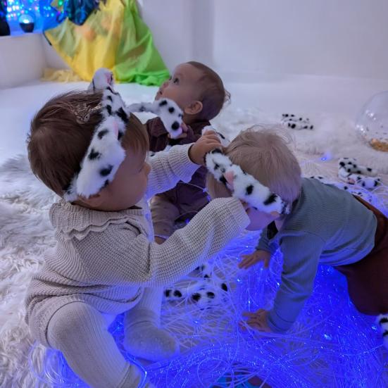 Tre små børn leget på et tæppe