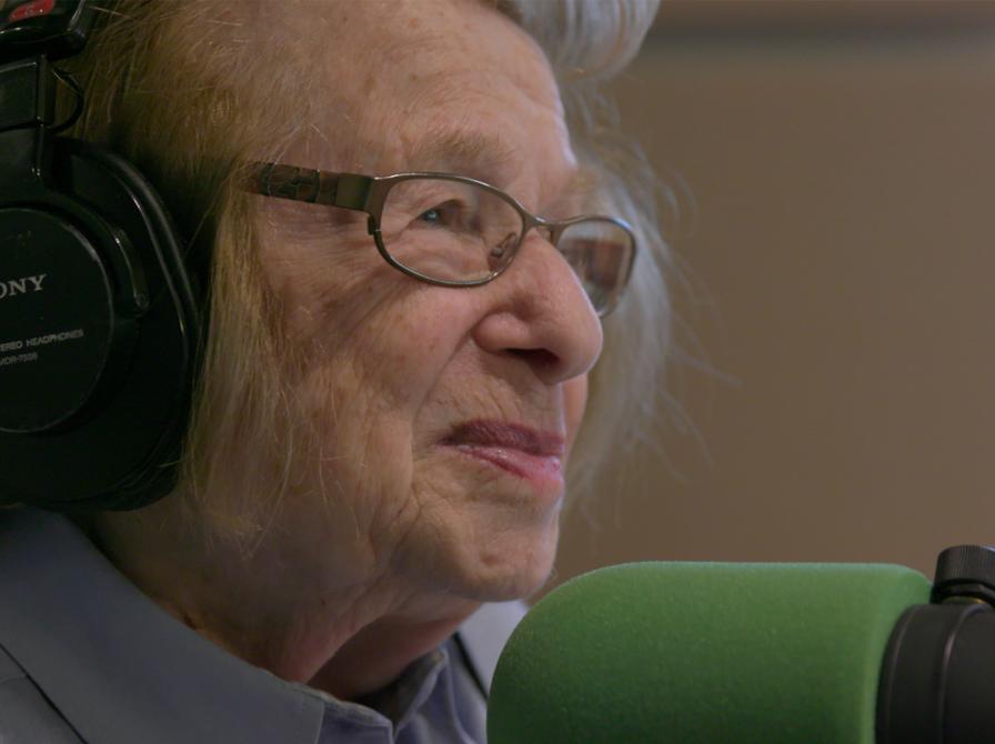 dr. ruth bliver interviewet foran en mikrofon og hun smiler