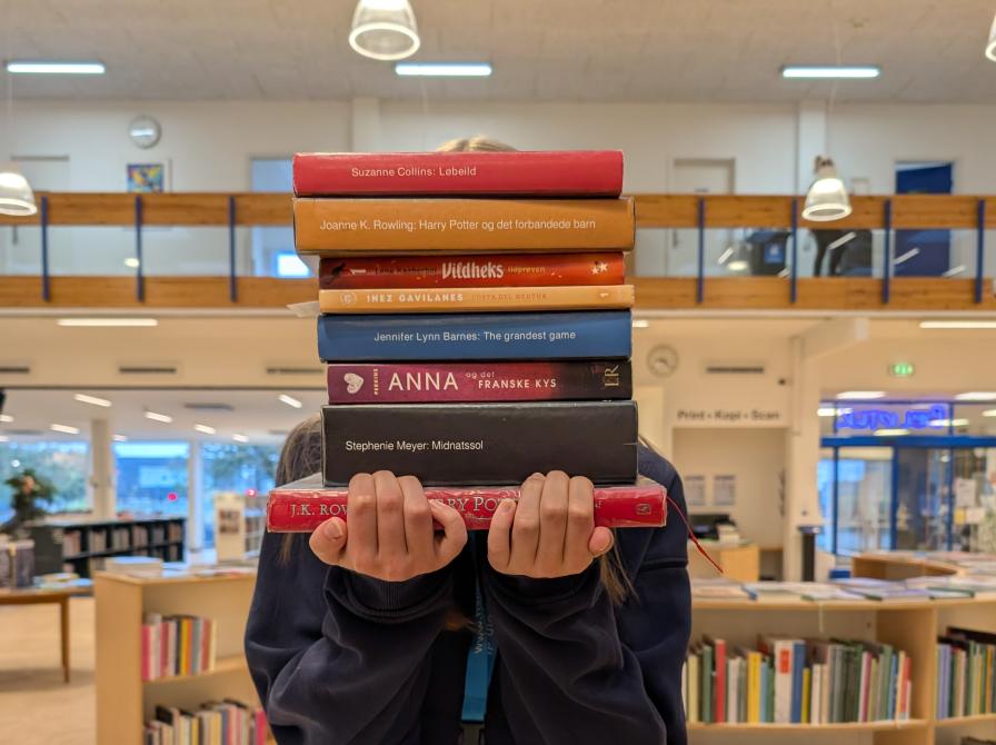 Praktikanten står og holder sine favorit bøger