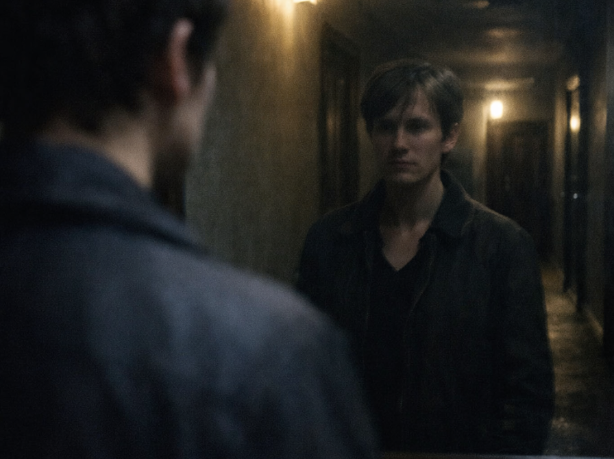 mand ser på sit eget spejlbillede i en gang