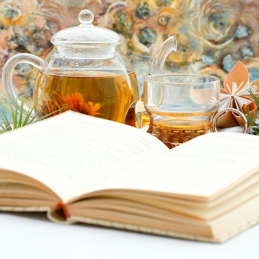 Foto af en åben bog og en kop te