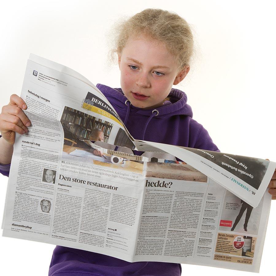Foto af barn der læser avis