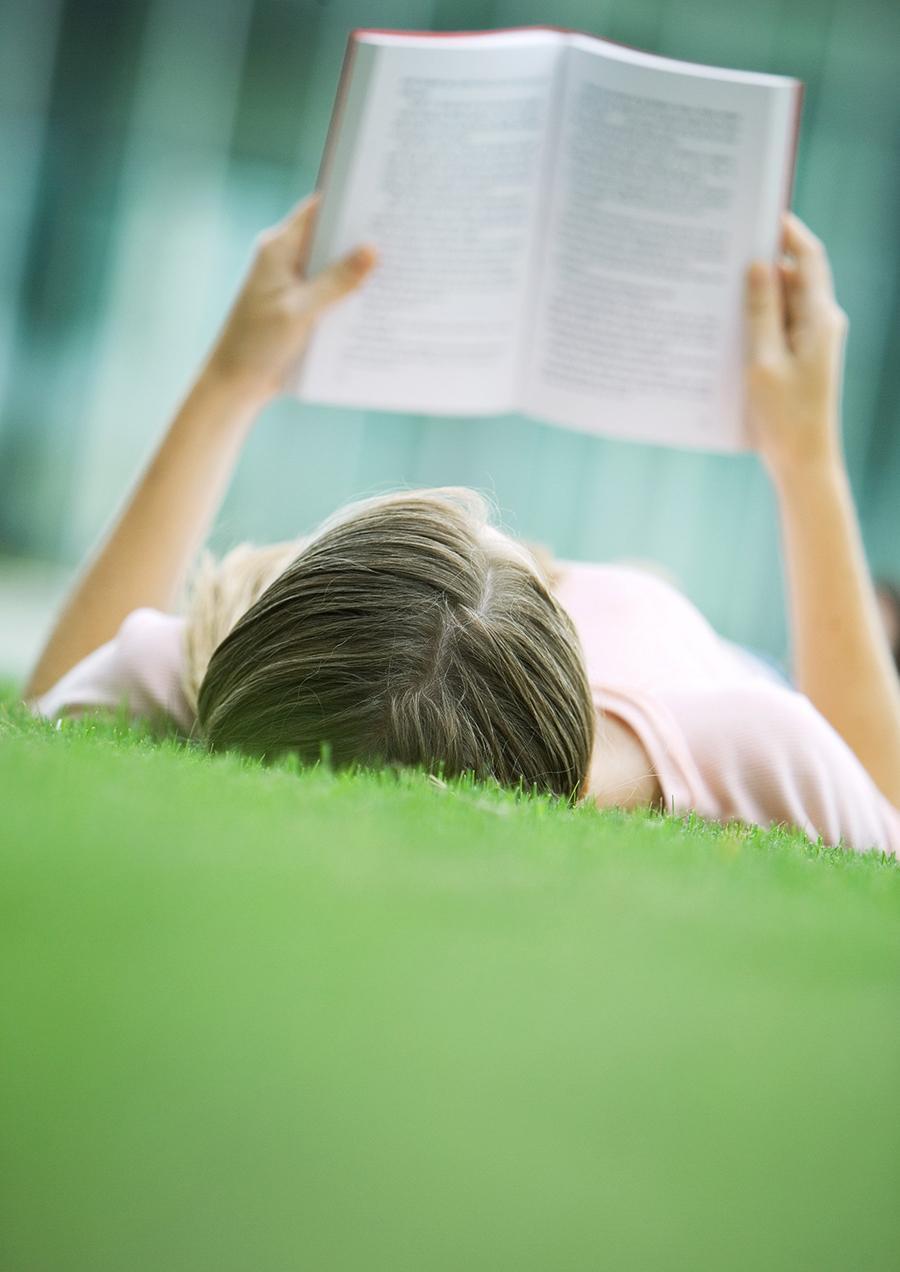 Kvinde ligger og læser