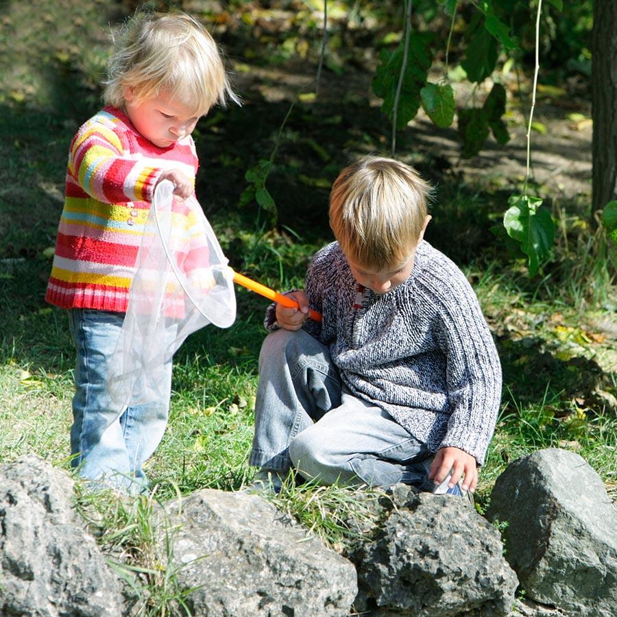 Foto af to børn der udforsker naturen