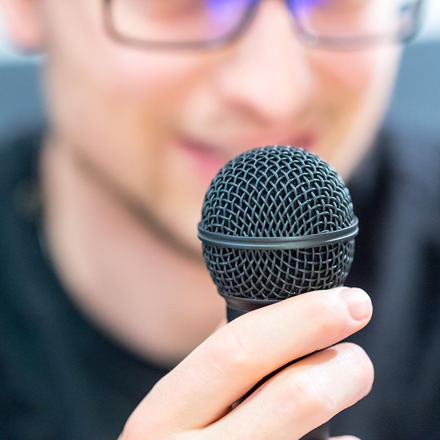 Foto af mand der taler ind i en mikrofon